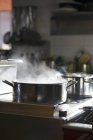 A pot of steaming water on a stove indoors — Stock Photo