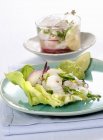 Ceviche on lettuce with an avocado cream on green plate over towel — Stock Photo