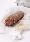 Вид крупным планом на котечинскую колбасу с веревкой на белой ткани — стоковое фото