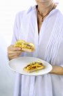 Cropped view of woman holding Crostini with anchovies and oranges — Stock Photo
