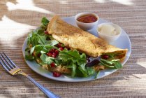 Closeup view of omelette with rocket and pomegranate seeds — Stock Photo
