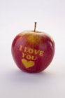 Vista close-up de maçã vermelha esculpida com as palavras Eu te amo e um coração — Fotografia de Stock
