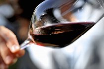 Glass of red wine held at angle — Stock Photo
