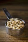 Amendoins em um copo de medição — Fotografia de Stock
