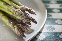 Fresh green asparagus on plate — Stock Photo