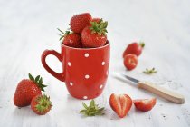 Frische Erdbeeren in roter Tasse — Stockfoto