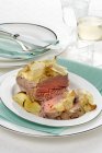Oven-baked tuna fish with a potato crust  on white plate  over towel — Stock Photo