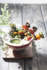 Vegetable kebabs with mint sauce in bowl over wooden surface — Stock Photo