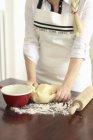 Женщина месит тесто на муковом прилавке — стоковое фото