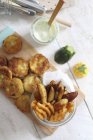 Battered courgette slices, potato wedges and lattice potatoes with a dip on wooden surface — Stock Photo