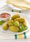 Pea croquettes with a tomato dip  on white plate over towel — Stock Photo