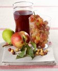 Closeup view of fresh fruit, hazelnuts and red wine on towel — Stock Photo