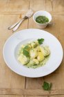 Wild garlic gnocchi  on white plate over wooden surface — Stock Photo