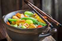 Паровые овощи с курицей в миске с палочками — стоковое фото
