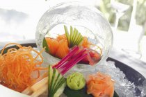 Primo piano vista di Sashimi su un piatto di servizio e all'interno di una palla di ghiaccio decorativa — Foto stock