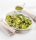 Courgette salad on plate with sauce — Stock Photo