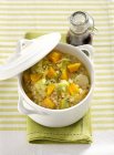 Orzotto vegetariano barley risotto with vegetables in white saucepan over towel — Stock Photo