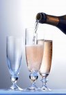 Розовое шампанское наливают в бокалы — стоковое фото