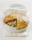 Closeup view of cut chicken pie in white baking dish on towel — Stock Photo