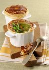 Vegetable soup topped with a puff pastry crust in white pots over wooden desk — Stock Photo