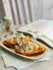 Sweet potato filled with Coronation chicken on wooden plates over table — Stock Photo