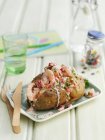 Quick jacket potato with prawns on small plate over table — Stock Photo