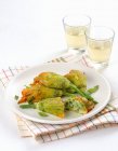 Fiori di courgette con un ripieno vegetariano su piatto bianco sopra asciugamano — Foto stock