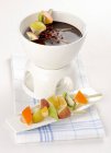 Chocolate fondue with fruit kebabs — Stock Photo