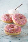 Рожеві глазуровані пончики з цукровими зморшками — стокове фото