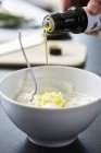 Крупный план ручной выливки льняного масла на Кварка — стоковое фото