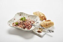 Салат из быка на тарелке с багетами — стоковое фото