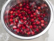 Cherries in bowl of water — Stock Photo
