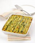 Courgette bake in white dish over towel — Stock Photo