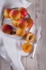 Apricots on plate over towel — Stock Photo