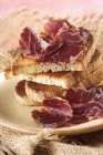 Italian mutton ham with toasts — Stock Photo