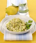 Risotto alle zucchine - ризотто с лимоном на белой тарелке поверх полотенца — стоковое фото