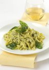 Tagliolini pasta with basil sauce — Stock Photo