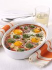 Spinach and egg bake in white dish over white surface — Stock Photo