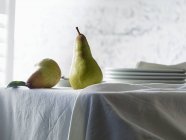 Reife Birnen auf weißer Tischdecke — Stockfoto