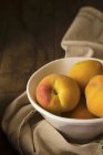 Peaches in ceramic bowl — Stock Photo