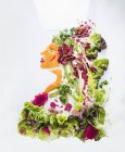 Ritratto di una donna fatta di lattuga, verdura e frutta su una superficie bianca — Foto stock