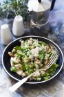 Mushroom and pea risotto with parsley in black plate with fork — Stock Photo