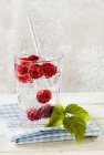 Mineral water with fresh raspberries — Stock Photo