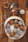 Primer plano vista superior de las bolas de fecha laminadas en cacao en polvo y coco desecado - foto de stock