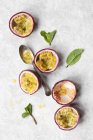 Passionfruit halves and mint leaves — Stock Photo