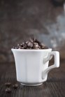 Chicchi di caffè in tazza — Foto stock