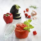 A jar of ajvar and fresh ingredients in the background — Stock Photo
