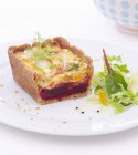 Rote Bete und Fenchelquiche mit Salat auf weißem Teller — Stockfoto