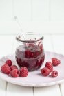 Jar of raspberry jam with spoon — Stock Photo