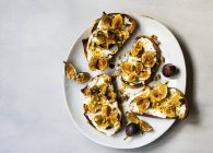 Vista superior de tostadas con higos en yogur griego con nueces picadas - foto de stock